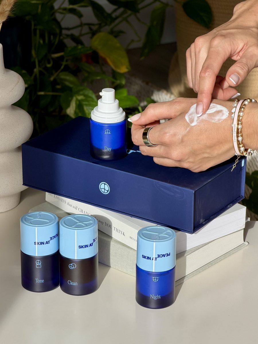 Hands smoothing Day into skin beside the Full System box and bottles.